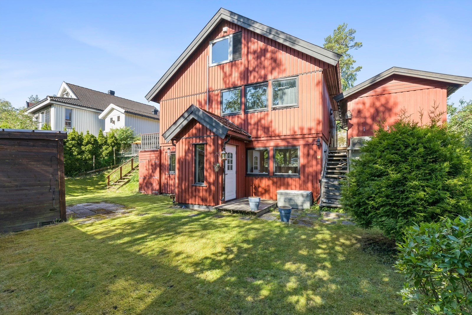 Det er inngang til huset både oppe og nede. Det går trapp fra både gårdsplass og terrassen ned til hagen på denne siden. Galleribilde