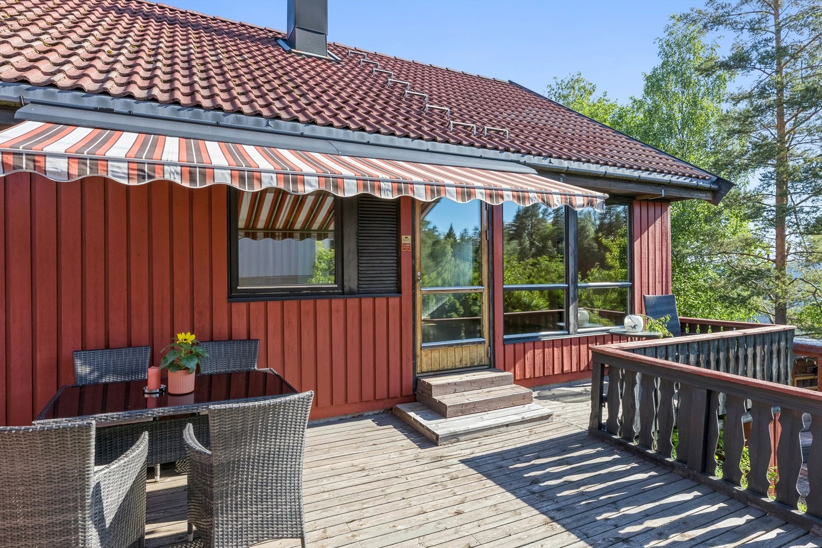 Romslig terrasse med utgang fra stuen. Det er markise her ute som skjermer mot solen på solfylte dager. Det går trapp fra terrassen ned til hagen på nedsiden av huset. Galleribilde