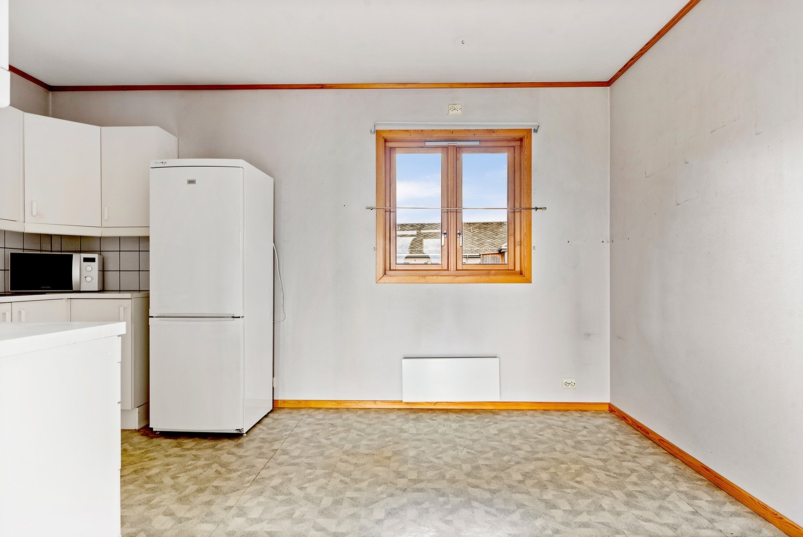 Belegg på gulv, og flis på vegg over benkeplate og malt glassfiberstrie på vegger. Galleribilde
