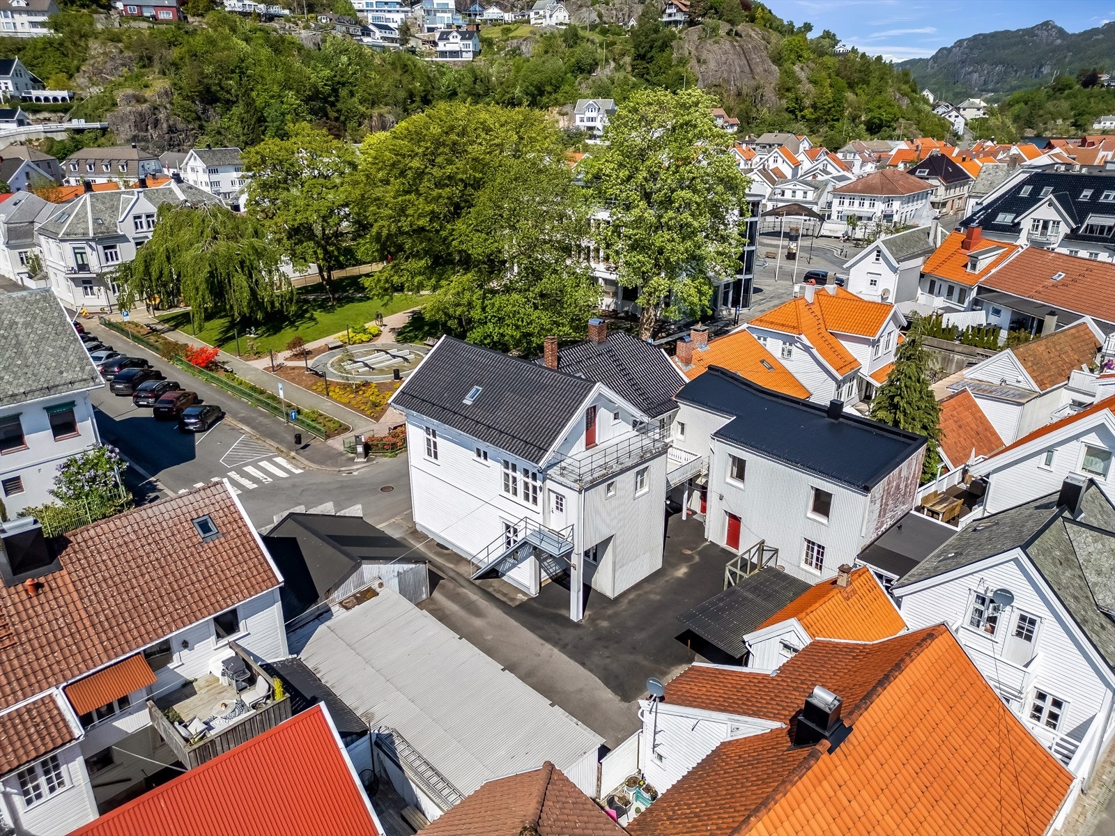 Stort asfaltert gårdsrom som rommer garasjer og carport. Galleribilde