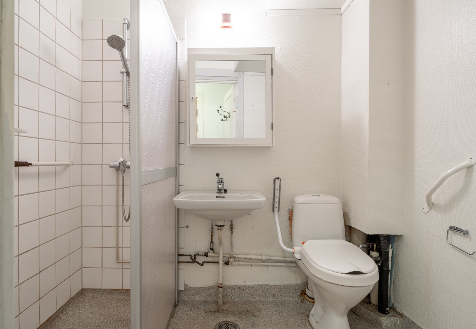 Baderom fra byggeår med vegger med fliser og malt strie. Galleribilde