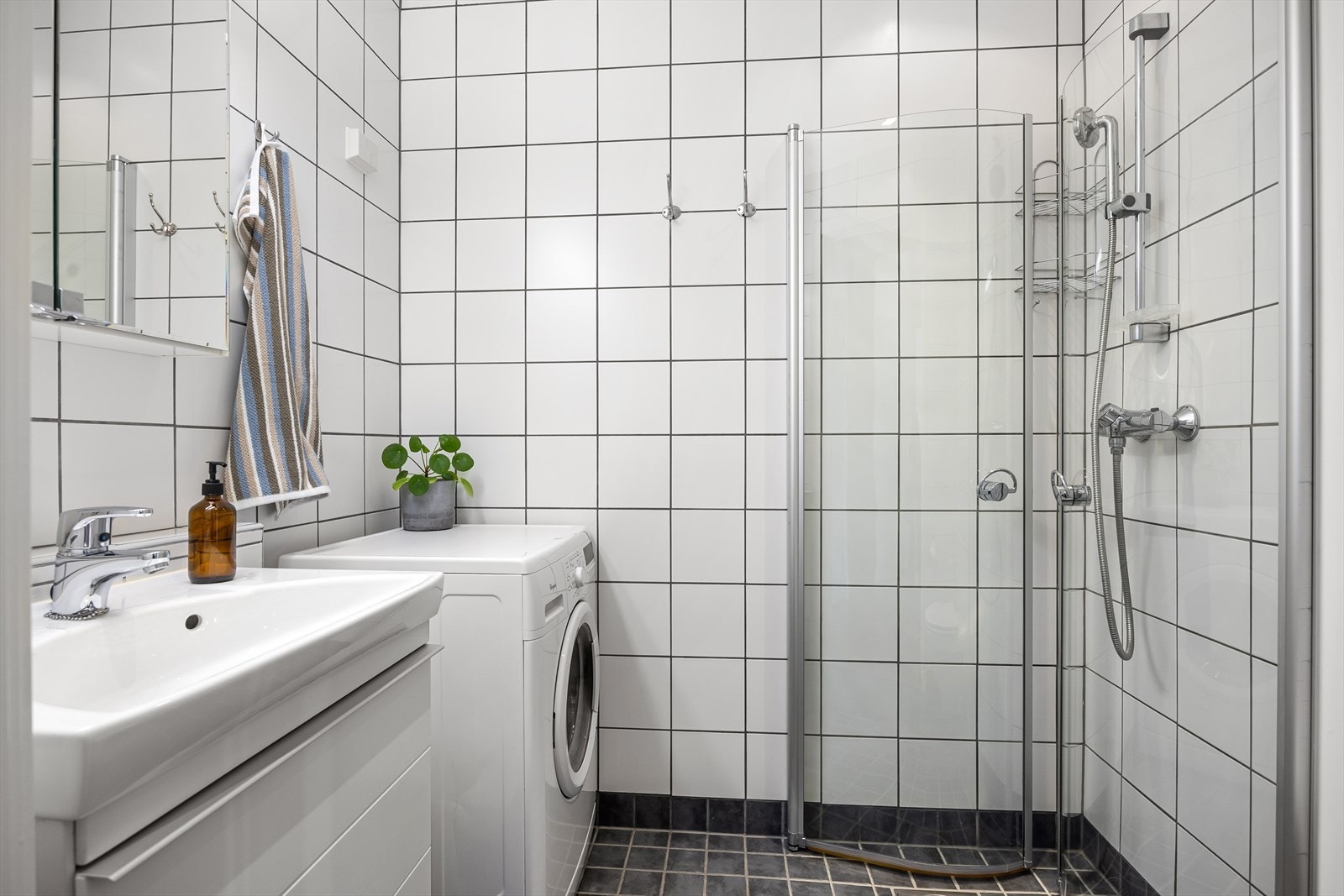 Pent flislagt baderom med downlights i himlingen og elektrisk gulvvarme. Det er opplegg for vaskemaskin. Galleribilde