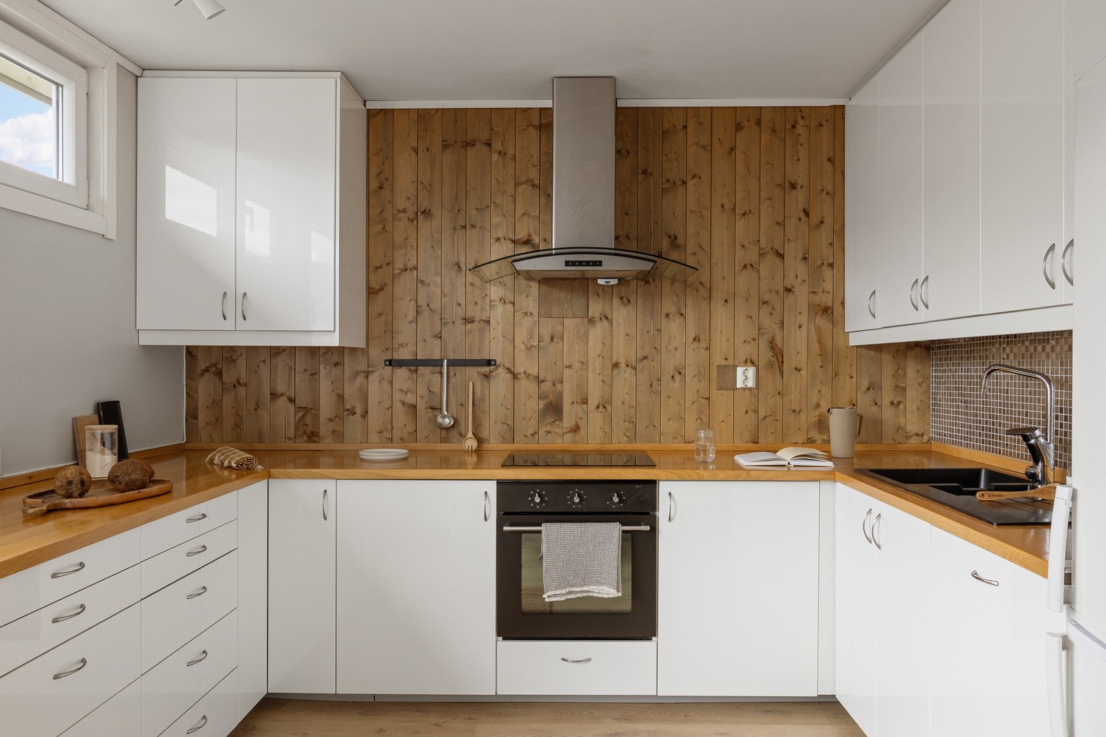 Kjøkkeninnredningen består av slette hvite høyglans fronter, heltre benkeplate med nedfelt vask av kompositt. Galleribilde