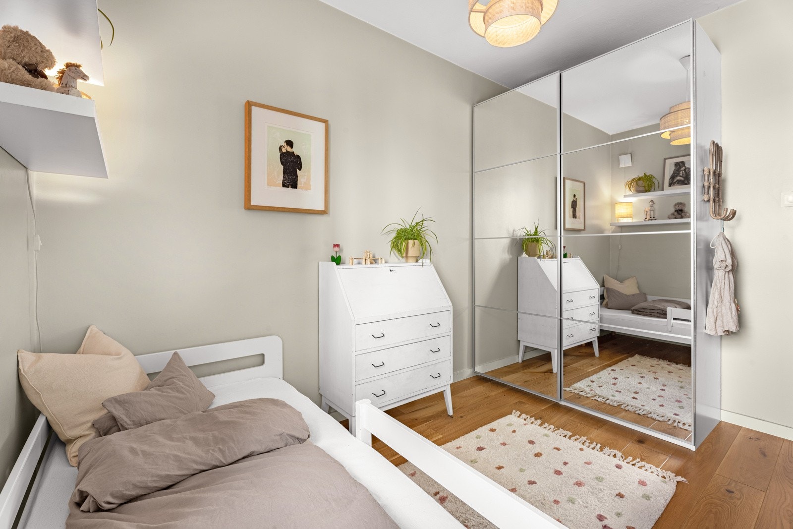 Barnerommet er innredet med en skyvedørsgarderobe som har speilfronter Galleribilde