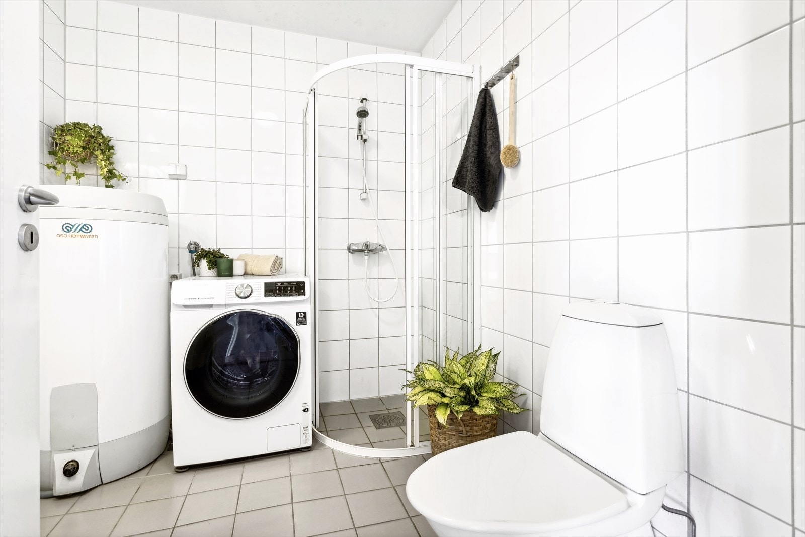 Badet er innredet med servant nedfelt i baderomsinnredning, dusjhjørne, wc og plass/opplegg for vaskemaskin og varmtvannsbereder. Galleribilde