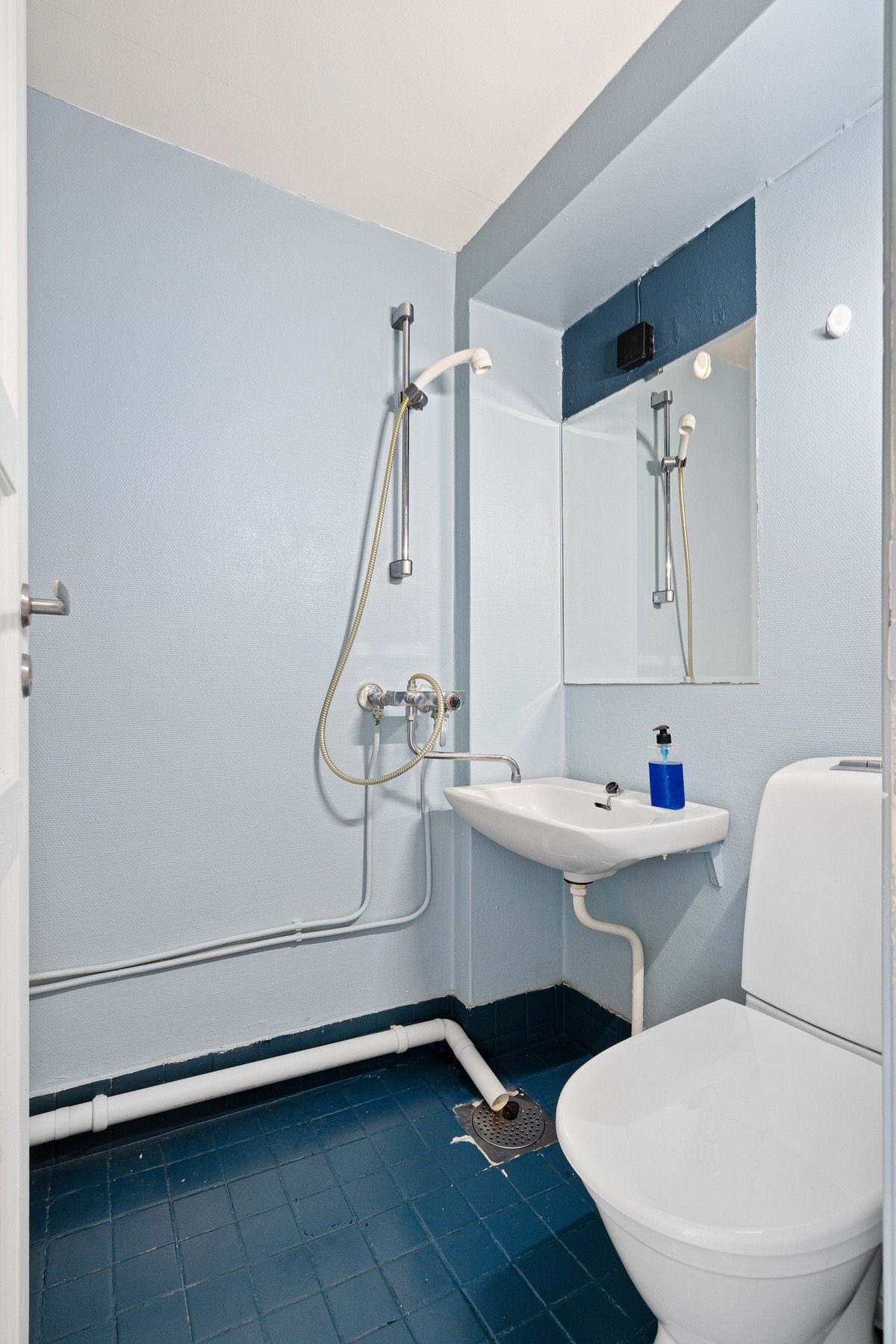 Badet er utstyrt med fliser på gulvet, dusj, toalett og mekanisk avtrekk. Galleribilde