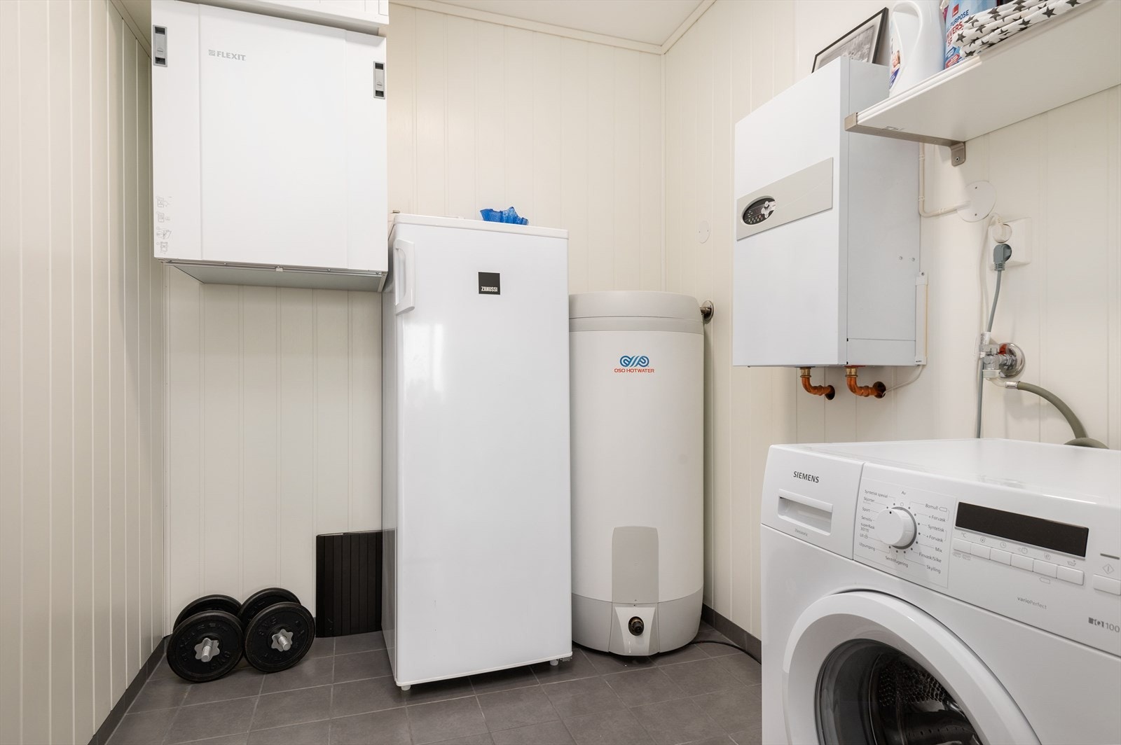 Vegg-i-vegg med badet har man et praktisk vaskerom. Galleribilde