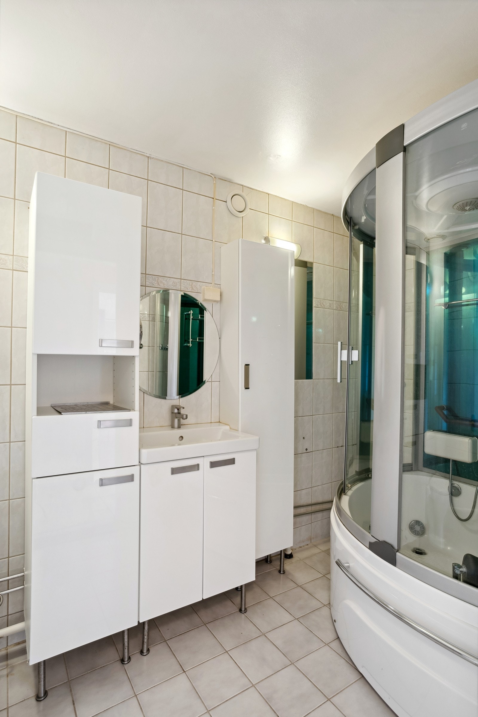 Flislagt bad med steamdusj/badkar og opplegg for vaskemaskin. Galleribilde