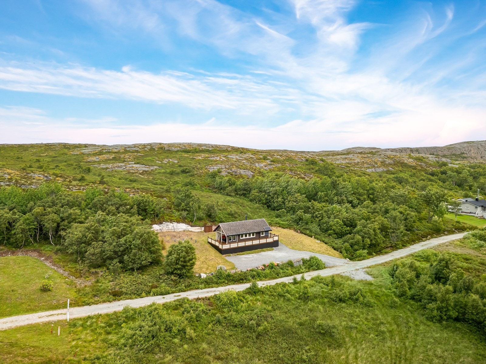 Dronefoto som viser eiendommens naturskjønne beliggenhet, og at det er god avstand mellom hyttene. Galleribilde
