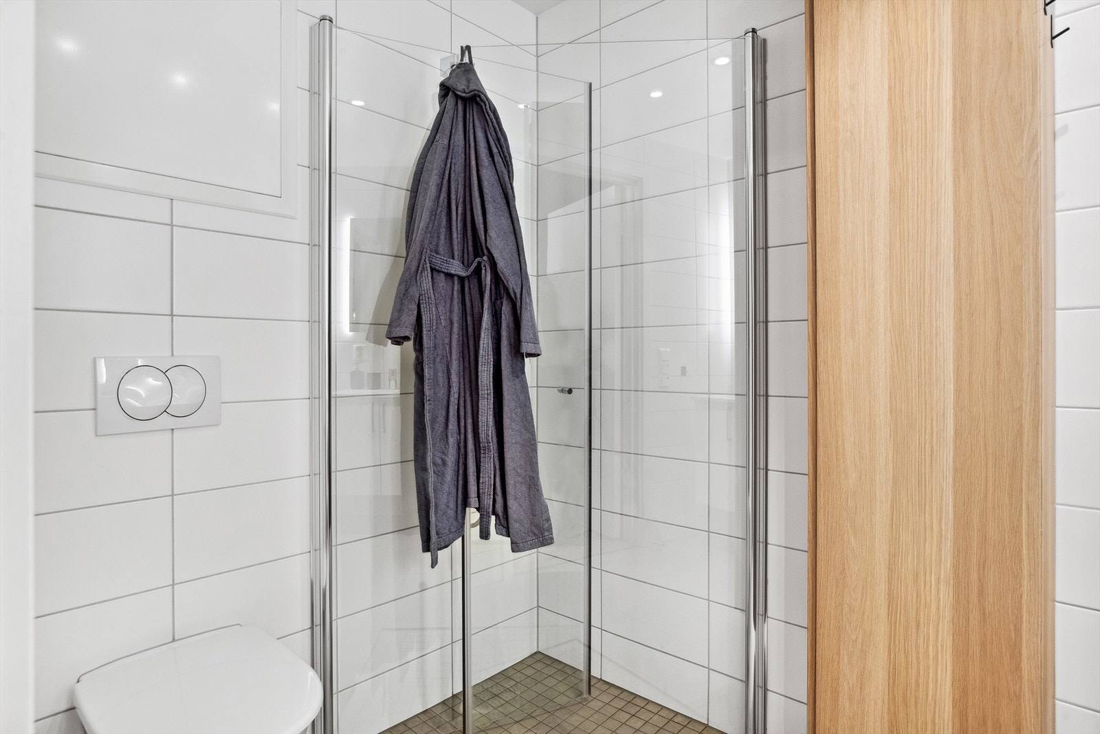 Badet er helfliset, måler ca. 4,5 kvm og har innfellbare glassdører i dusjhjørnet. Galleribilde