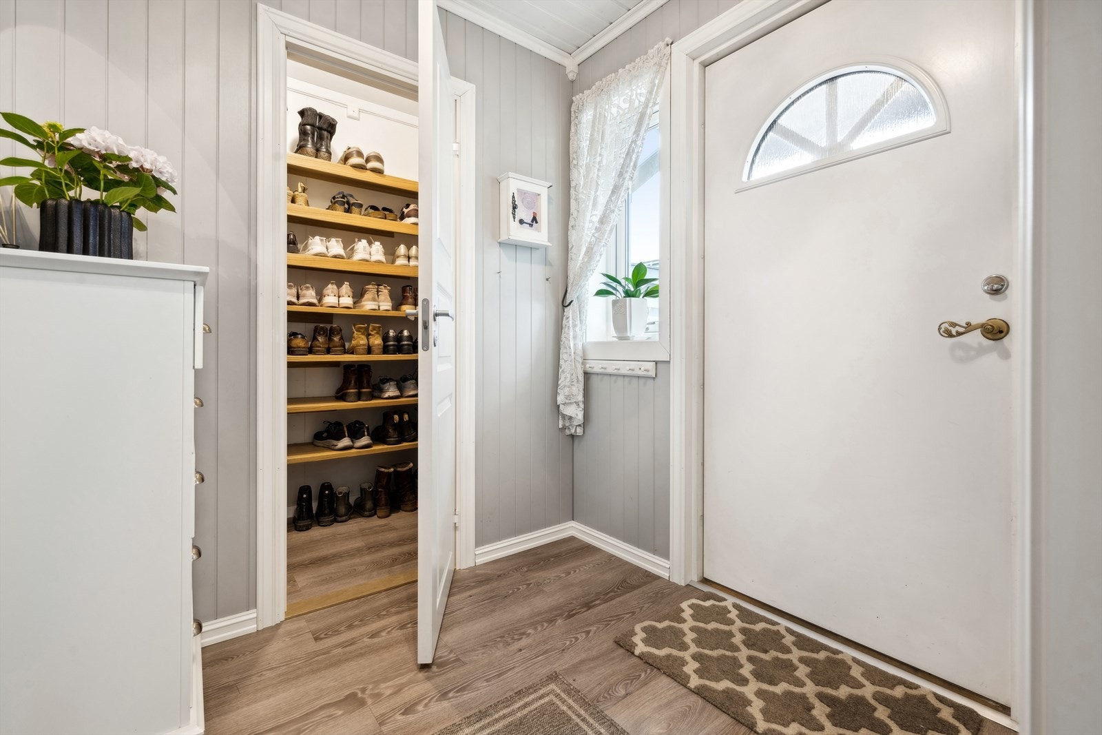Du ønskes velkommen inn i en lun entré med MDF-plater i en lys gråtone på veggene. Entreen har god plass til oppbevaring og oppheng til jakker og diverse. Det er innvendig bod som gir mulighet for oppbevaring eller som ekstra plass til yttertøy. Galleribilde