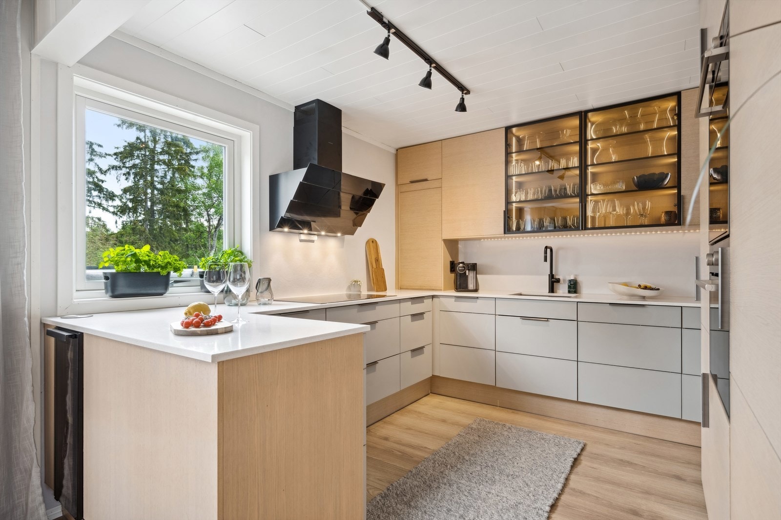 Her det benke- og overskap med slette fronter og benkeplate av stein. Galleribilde
