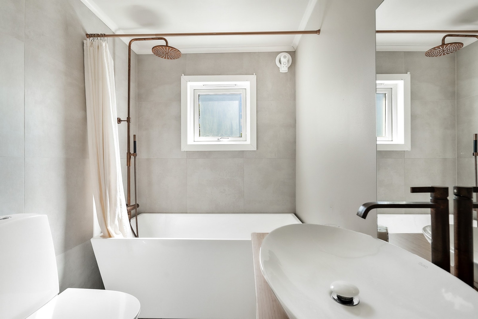 Badet er lyst og innbydende. Praktisk med både badekar og dusj Galleribilde