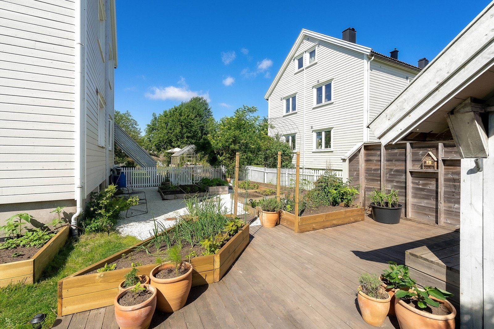 Pent opparbeidet og innholdsrik hage med veranda Galleribilde