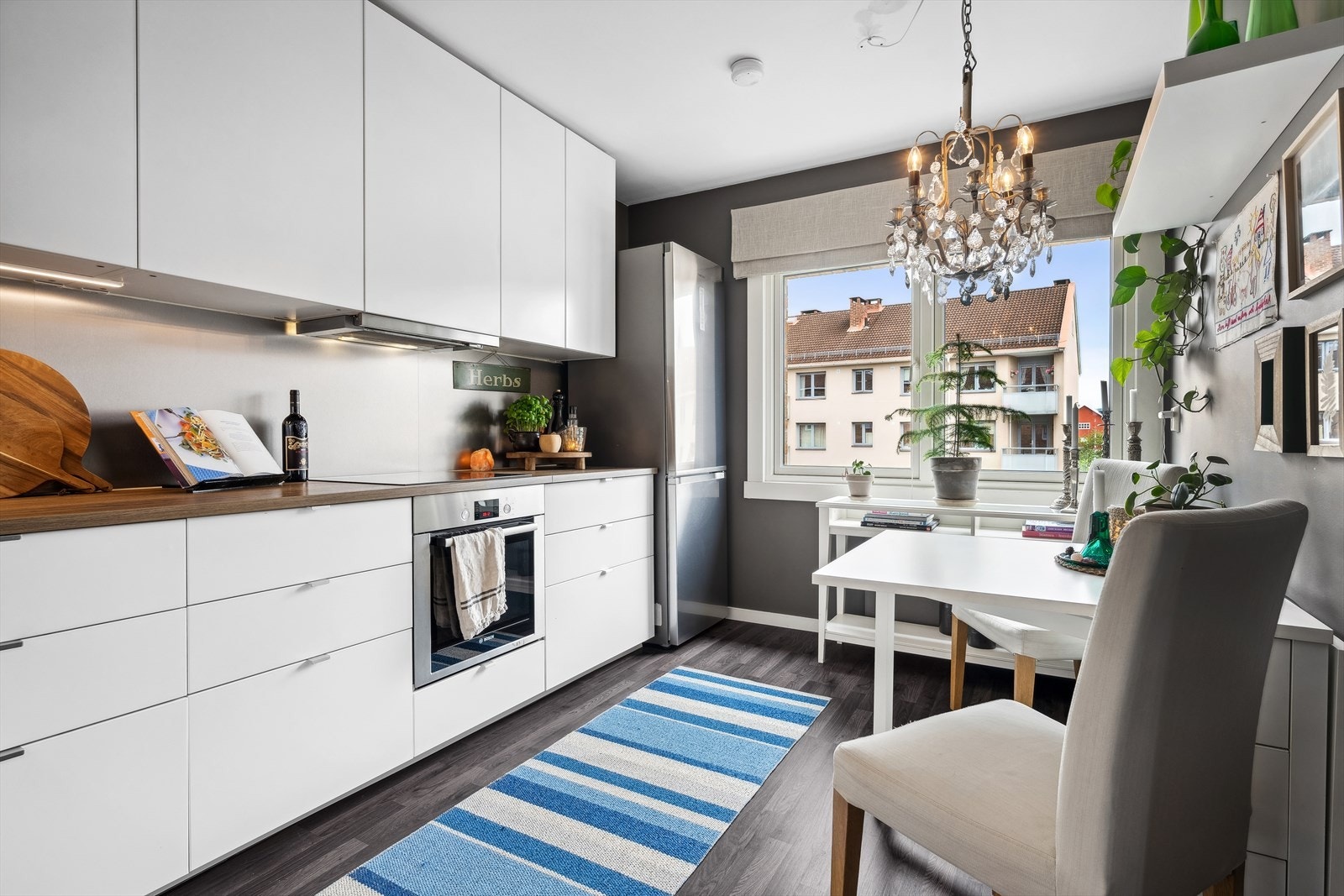 Kjøkkenet har en flott IKEA kjøkkeninnredning fra 2016, med glatte hvite fronter, benkeplate i laminat. Integrert oppvaskmaskin, stekeovn og induksjonstopp. Galleribilde