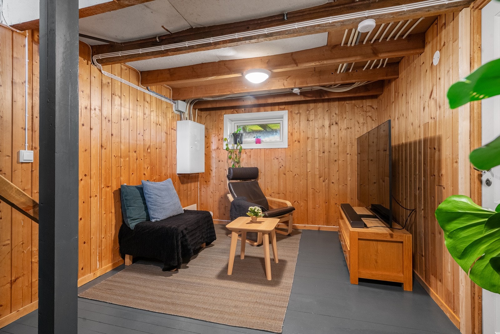 Kjelleretasje i dag innredet med stue, vaskerom og bod. Galleribilde