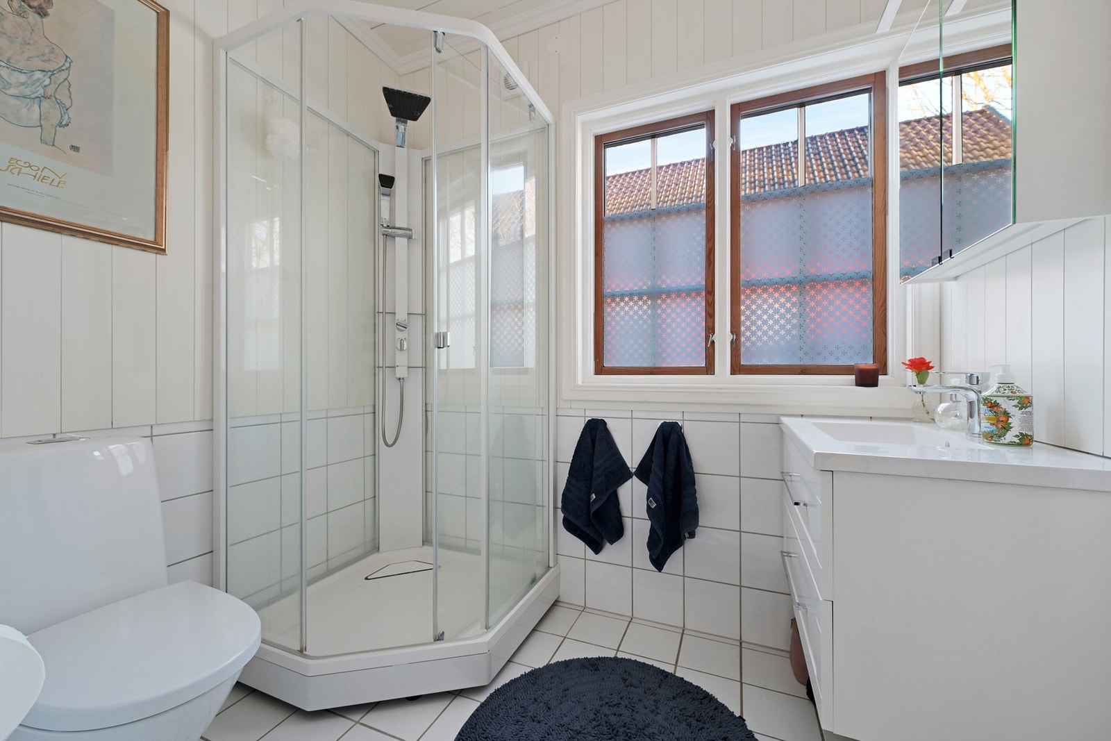 Lyst bad med god gulvvarme. Badet er utstyrt med servant med underskap, speil over servant og dusjkabinett. Galleribilde