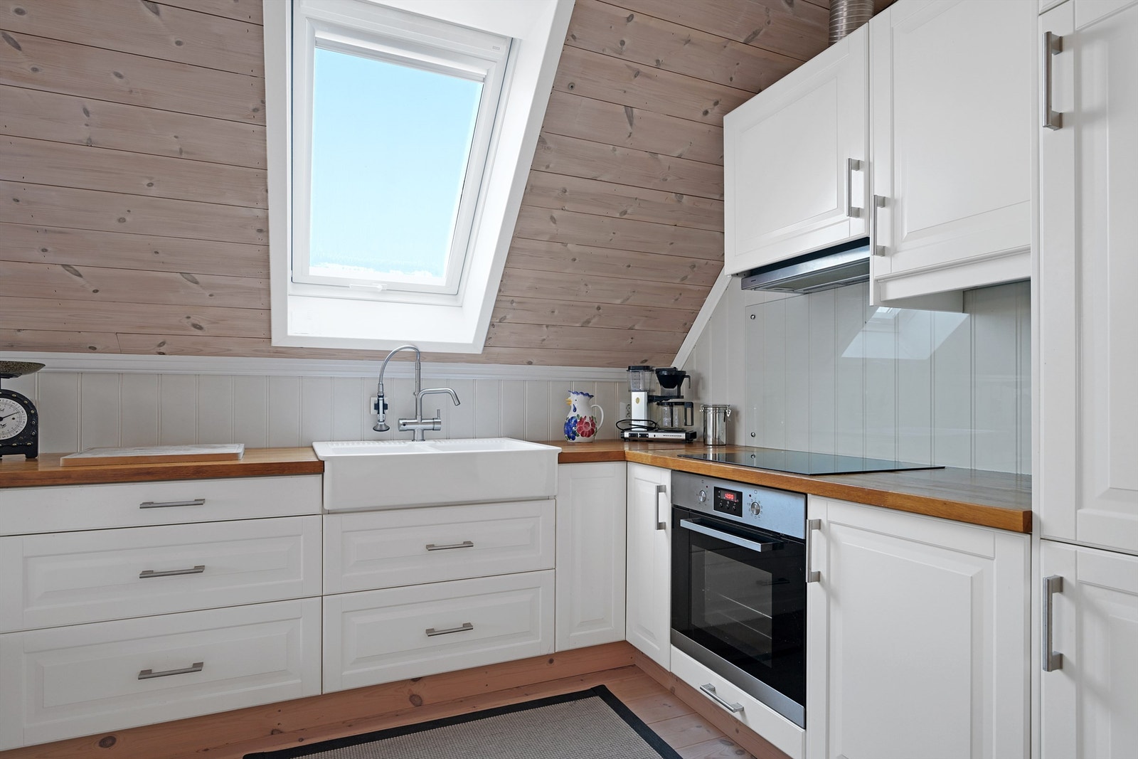 Kjøkkenet har innredning med profilerte fronter og en benkeplate av heltre. Det er kjøl/fryseskap, platetopp og stekeovn. Galleribilde