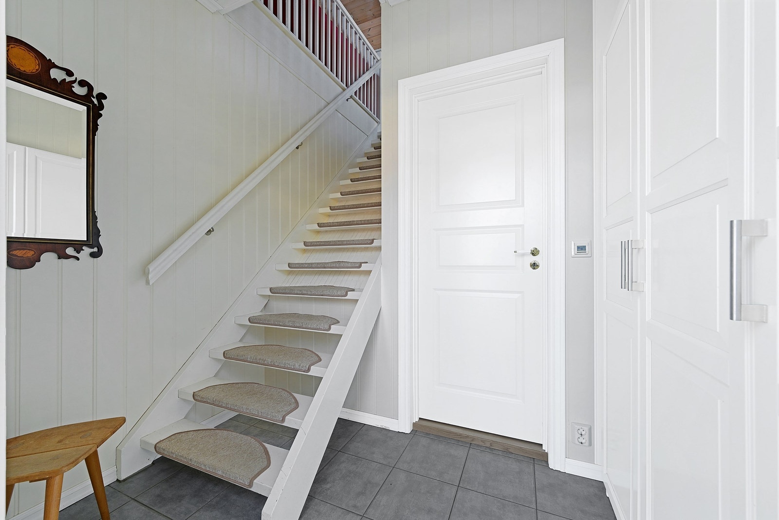 Entré i leilighetsdel av garasjen. Her er det garderobeskap til praktiskoppbevaring av ytterklær og sko. Galleribilde