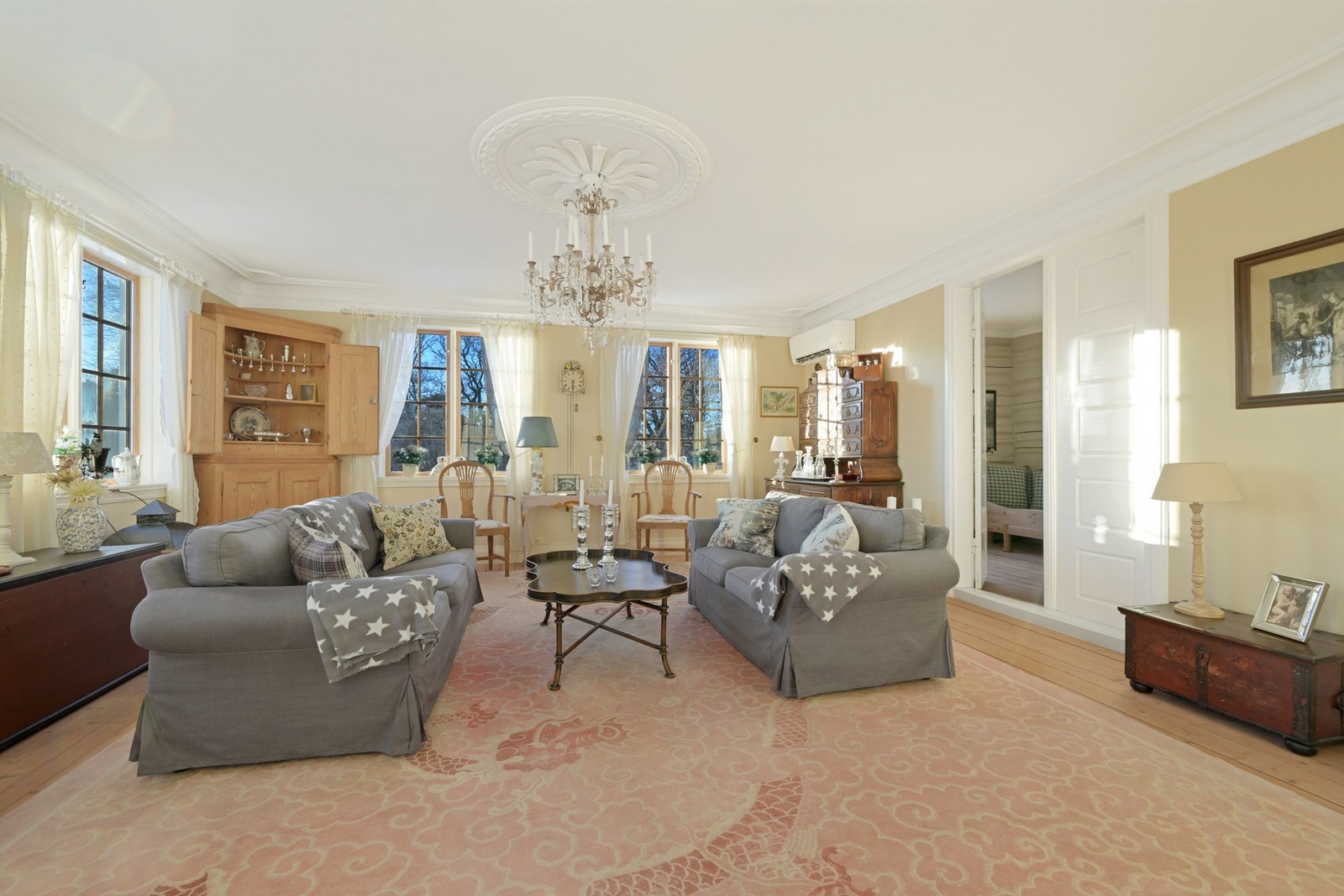 Lekre detaljer og en flott takrosett gir stuen et delikat uttrykk. Galleribilde