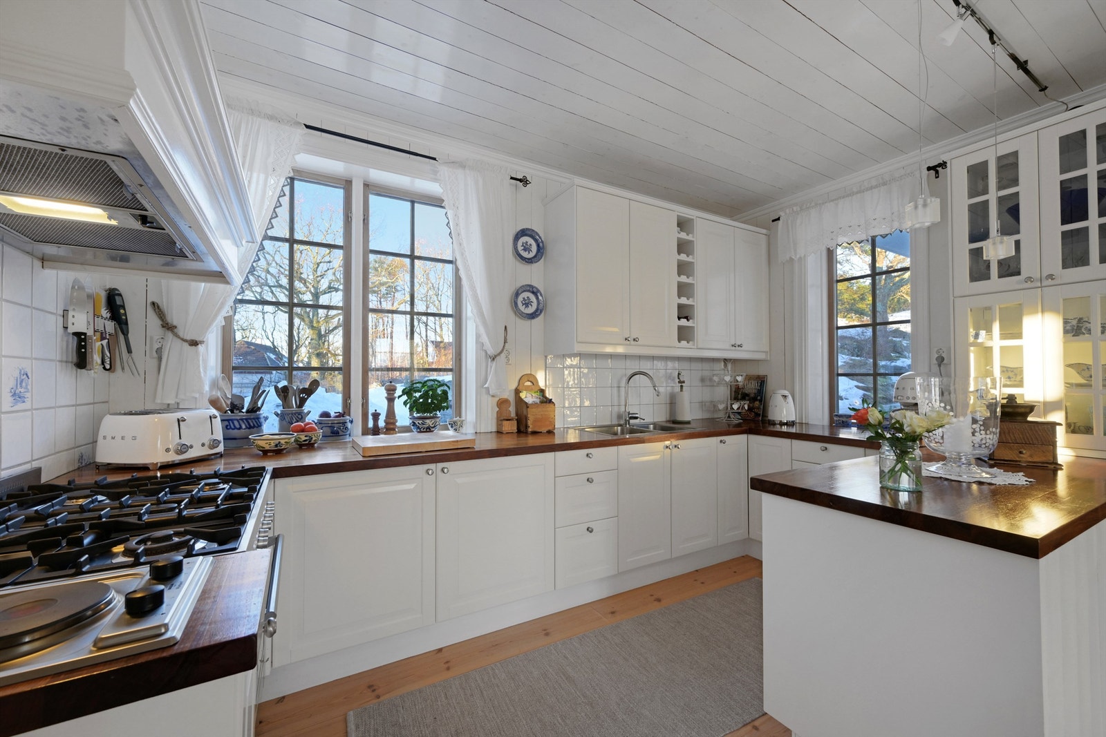 Lekkert kjøkken med lyse profilerte fronter og benkeplate av heltre. Galleribilde