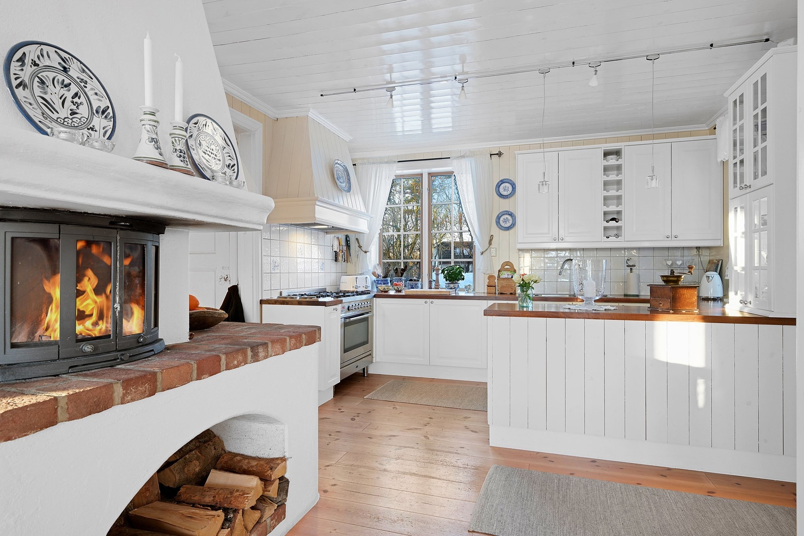 Mellom kjøkken og stuen er et flott ildsted som gir godt med varme. Galleribilde