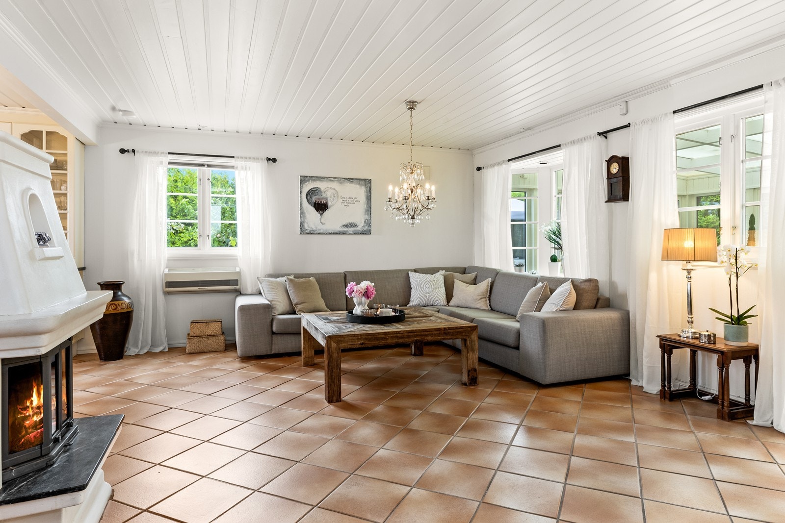 Stue i 1. etasje med lyse overflater på vegger og i himling, og med flislagt gulv Galleribilde