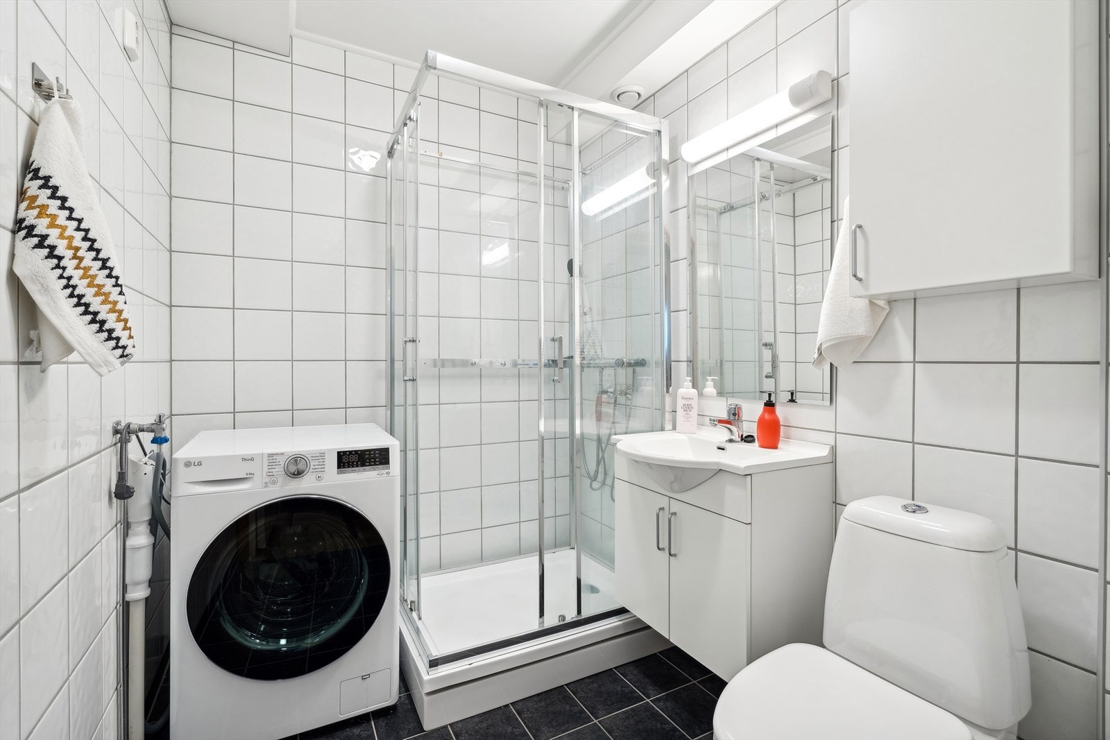 Praktisk og pent bad med nøytrale fliser og varmekabler. Galleribilde