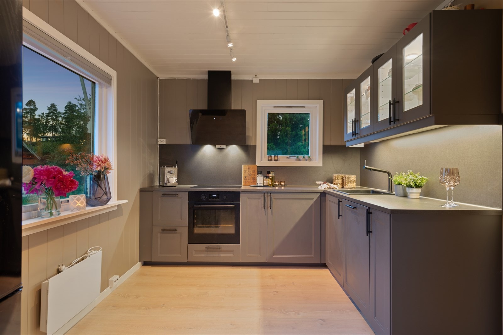 Pent kjøkken med profilerte fronter. Lys i og under overskap som gir rikelig med belysning til matlagingen på kveldstid. Galleribilde