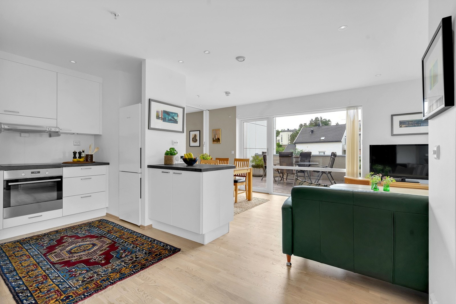 Åpen stue/kjøkken med store vindusflater som gir godt med naturlig lys Galleribilde