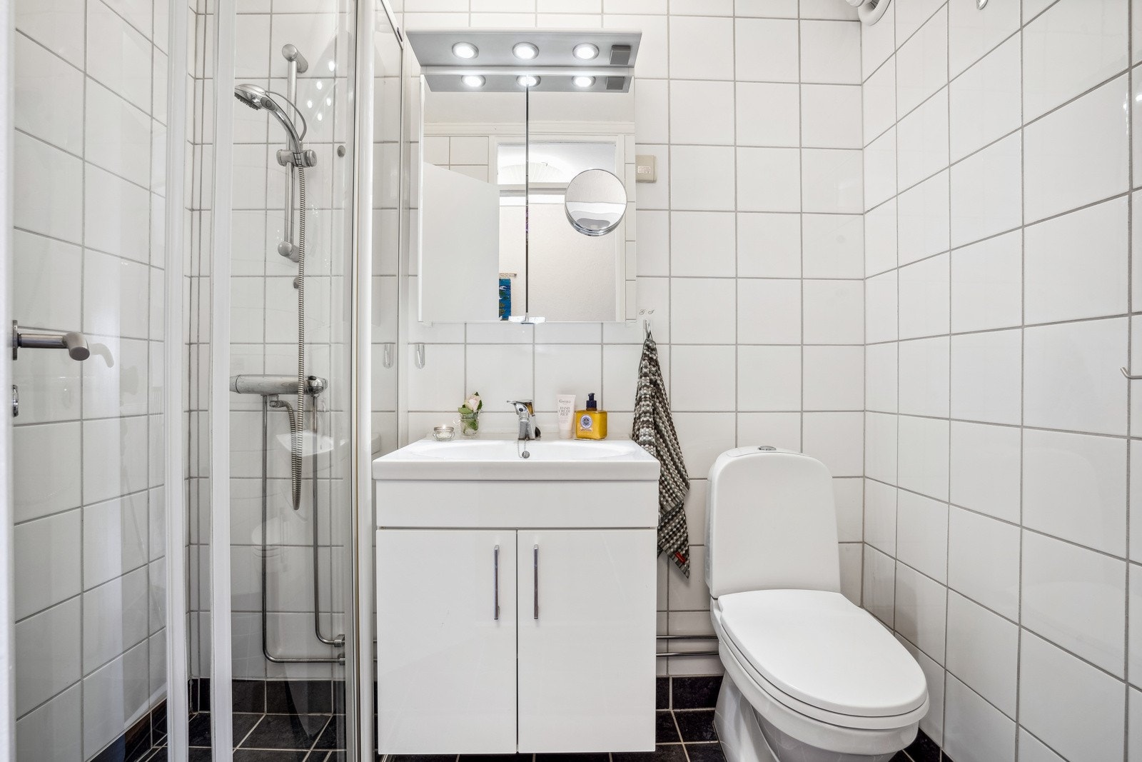 Det flislagte badet er svært arealeffektivt. Utstyrt med servantskap, toalett og dusjnisje. Behagelig gulvvarme. Galleribilde