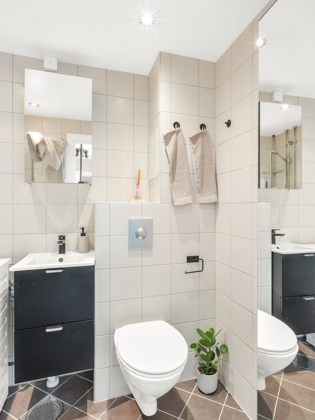 Badet har servant med underskap, speilskap, vegghengt toalett og dusjnisje med innfellbare dører Galleribilde