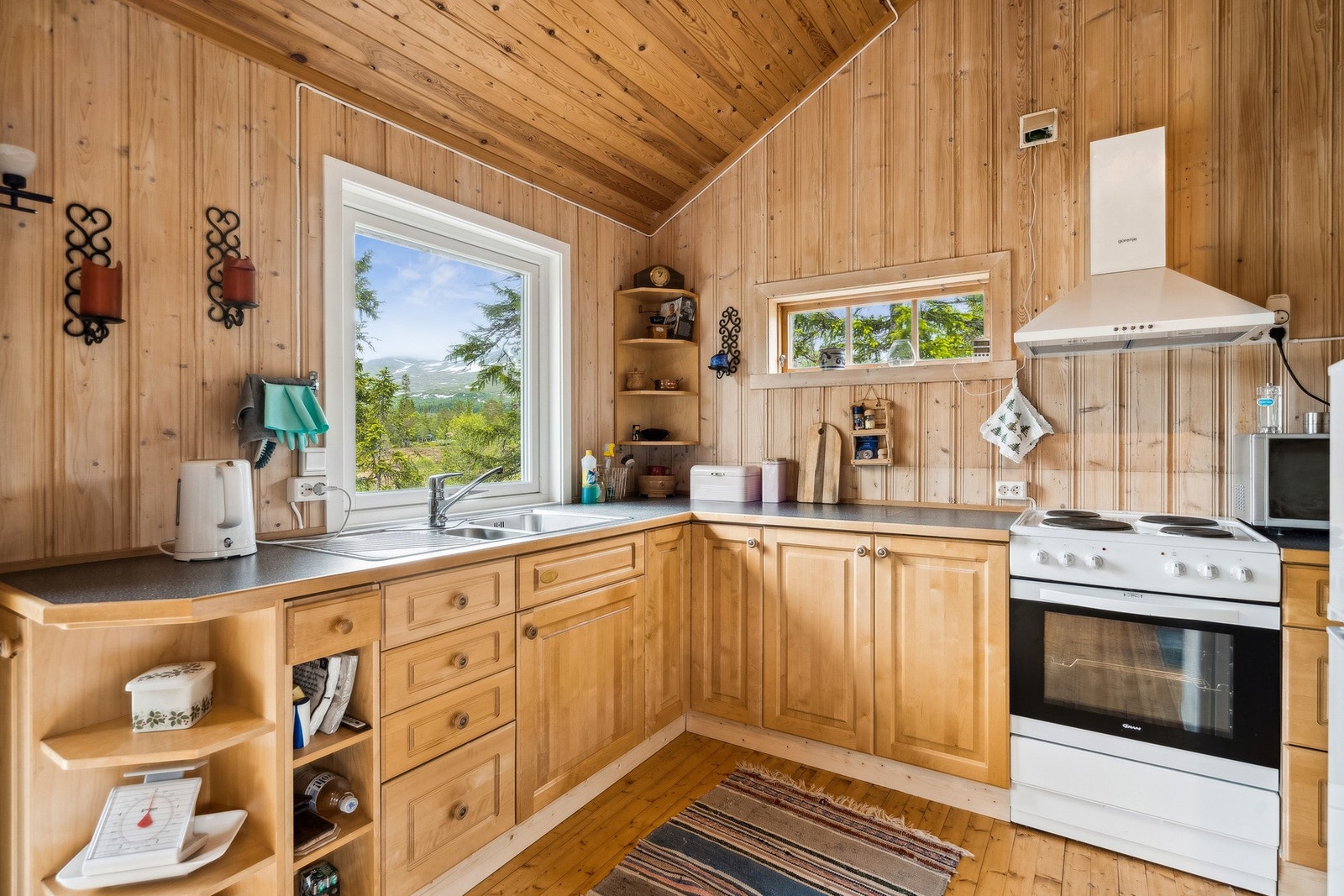 Plassbygd kjøkkeninnredning med frittstående komfyr. Galleribilde