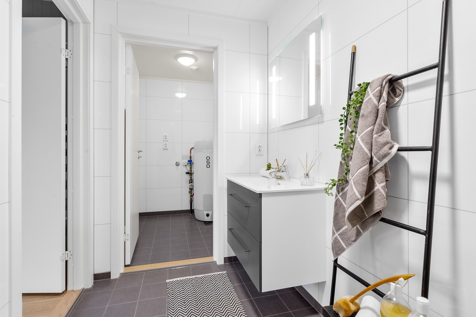 Badet i underetasjen har delikate hvite fliser på veggene samt grå fliser på gulvet med gulvvarme. Galleribilde