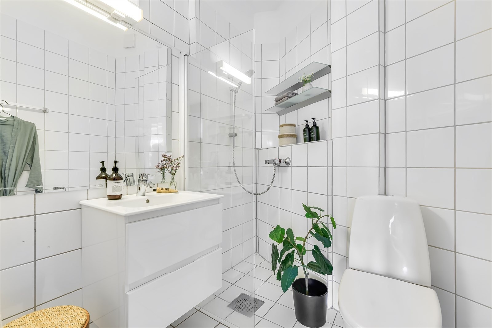 Badet er innredet med lyse fliser på vegger og gulv, samt gulvvarme Galleribilde