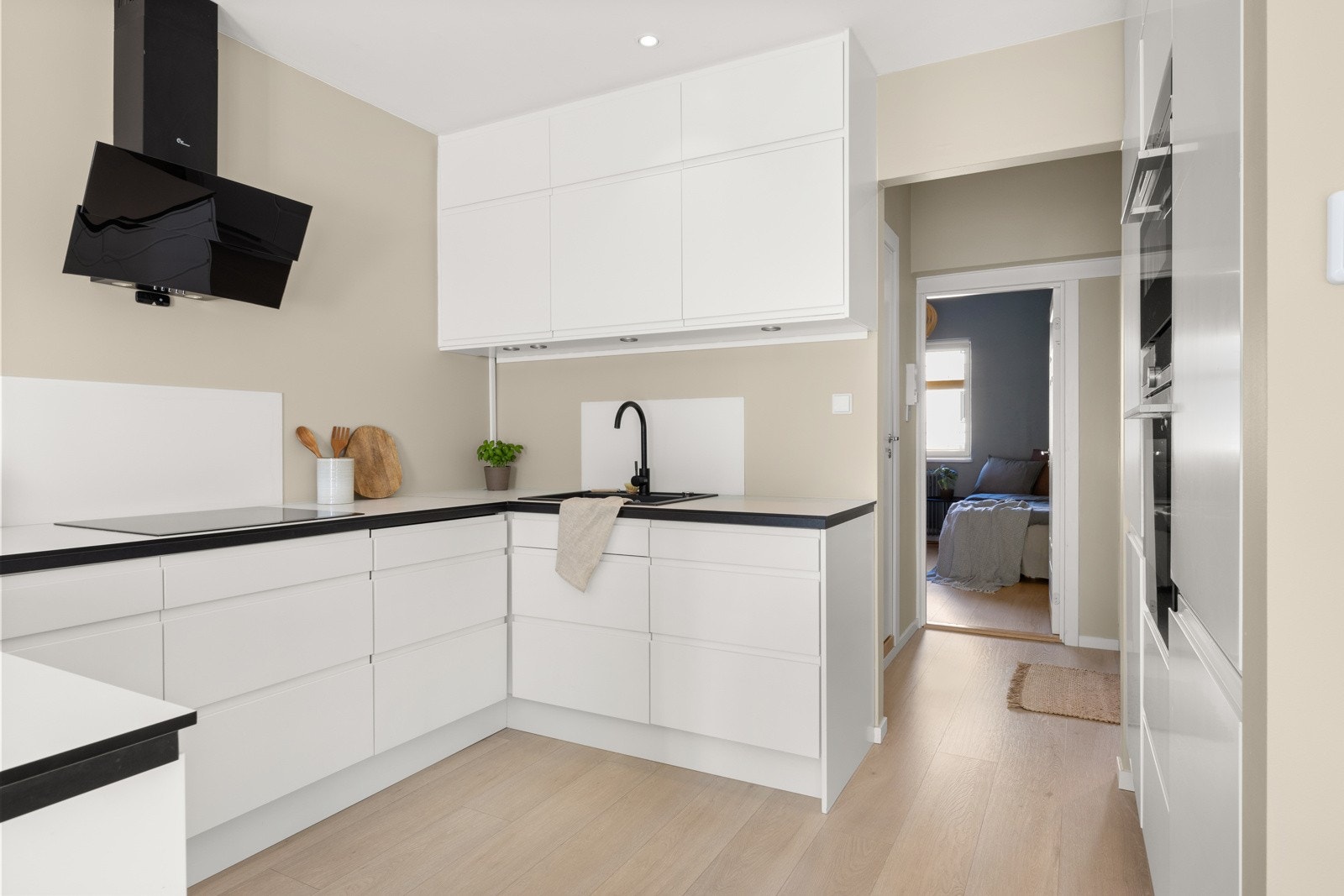 Innredningen har et moderne og stilrent design med lyse fronter og benkeplate av kompakt laminat. Galleribilde
