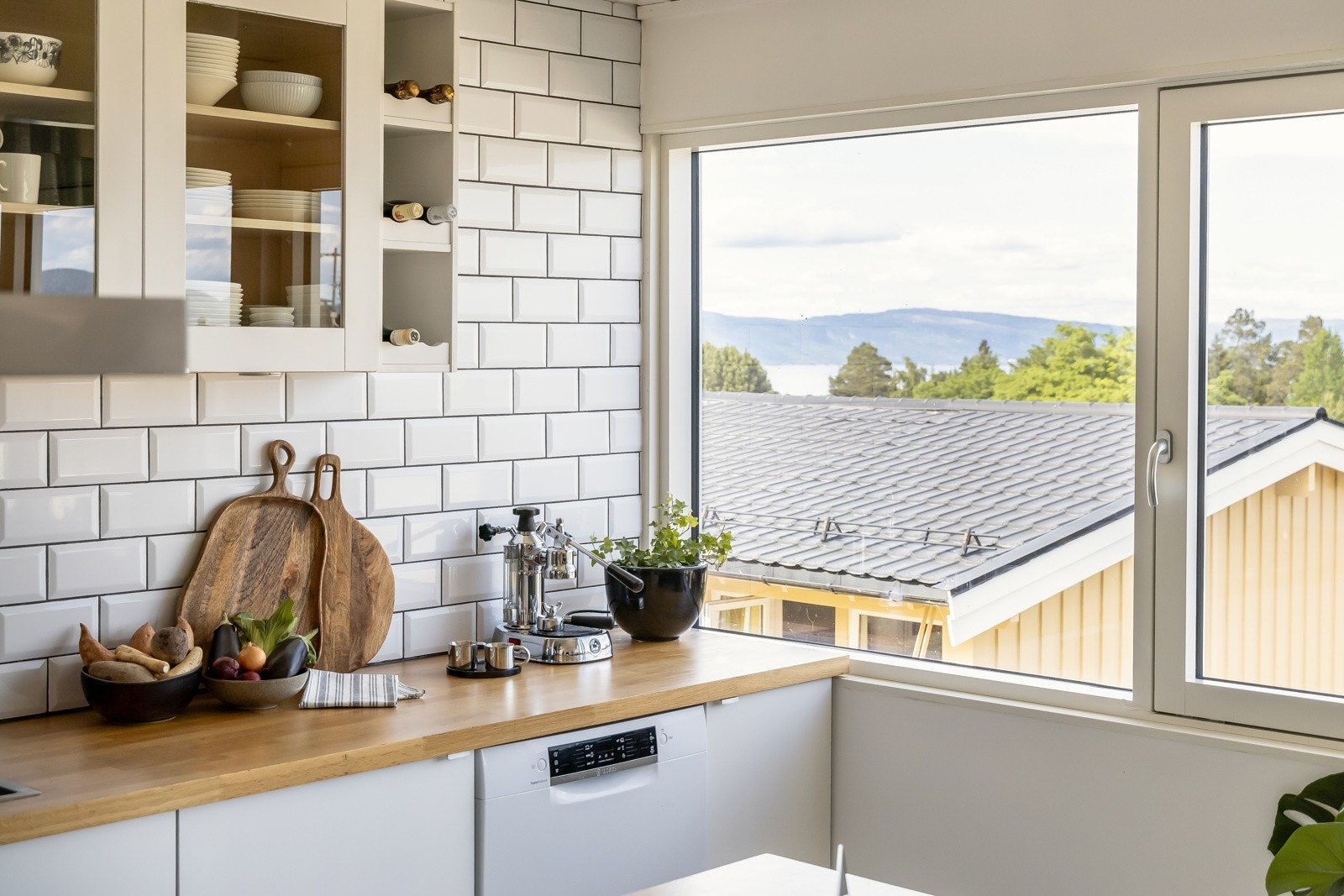 Klassiske subway-tiles på vegg og benkeplater i heltre eik. Galleribilde