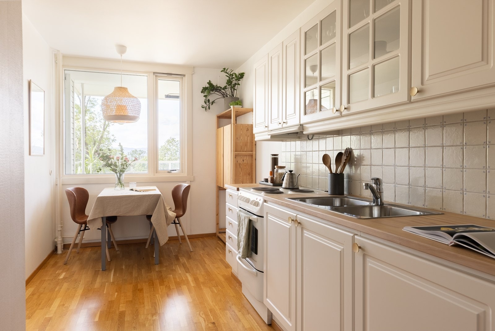 Kjøkkeninnredningen er fra 2002 og har hvite profilerte fronter, vitrineskap og benkeplater i heltre bøk. Nedfelt benkebeslag med oppvask-/skyllekum i rustfritt stål Galleribilde