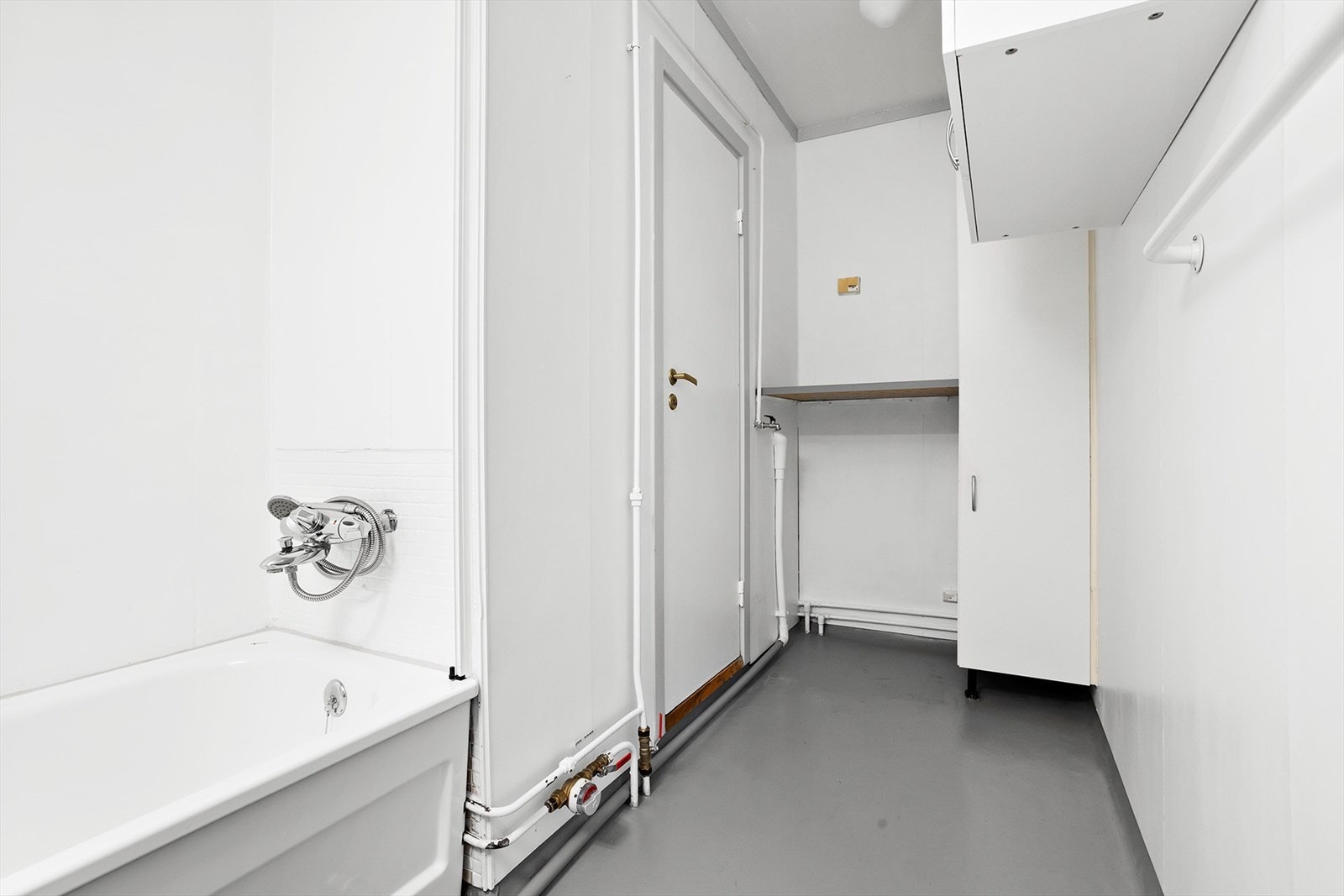 Bad med opplegg for vaskemaskin med benkeplate over samt høyskap. Galleribilde