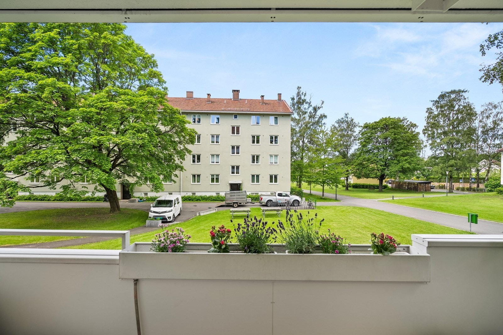 Hyggelig utsyn fra balkongen mot borettslagets grønne fellesarealer. Galleribilde