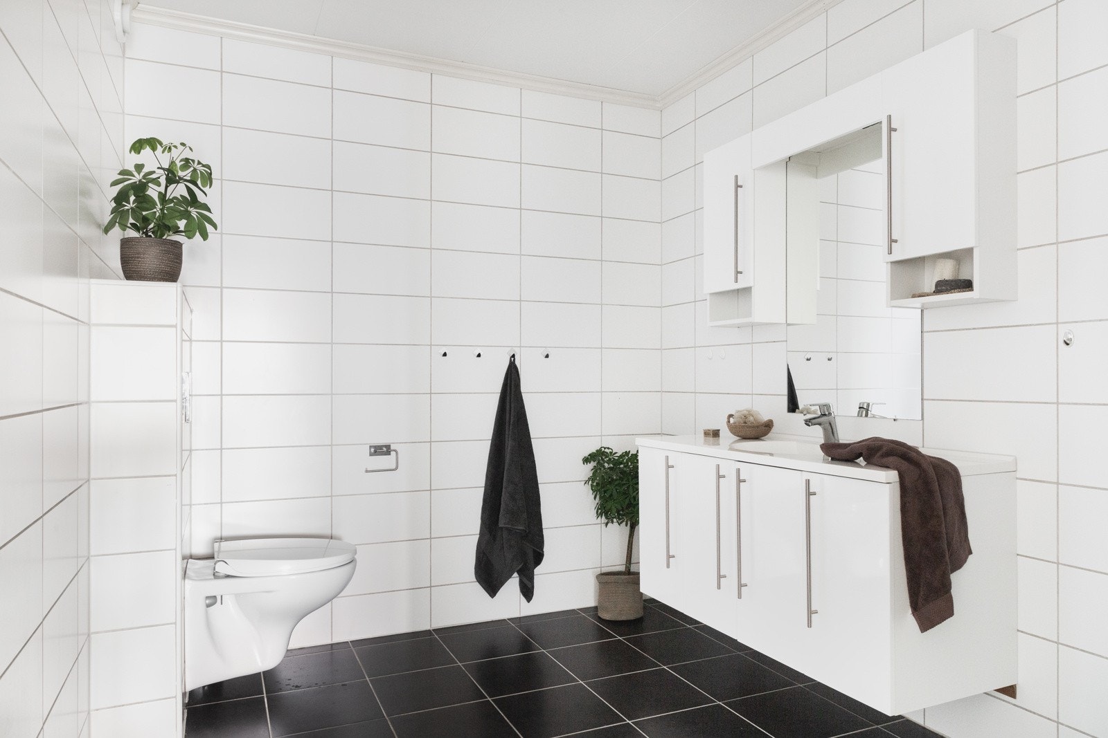 Badet inneheld dusjnisje med glasdør, vegghengt toalett og baderomsinnredning med heilstøpt servant. Galleribilde