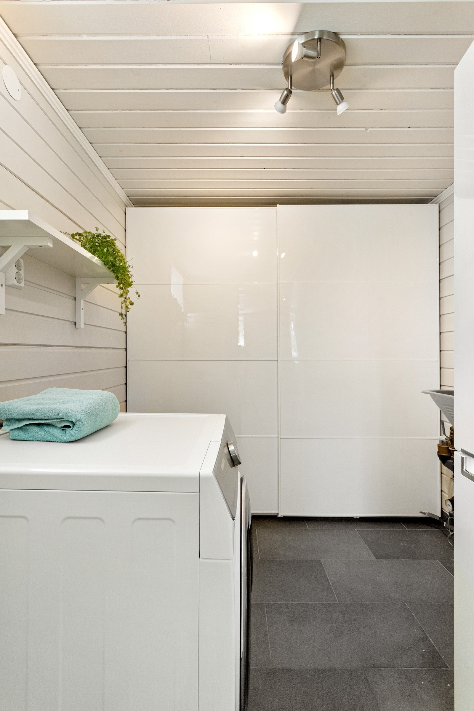 Vaskerom med innredet garderobeskap, vaskemaskin og varmvannsbereder på 300L. Galleribilde