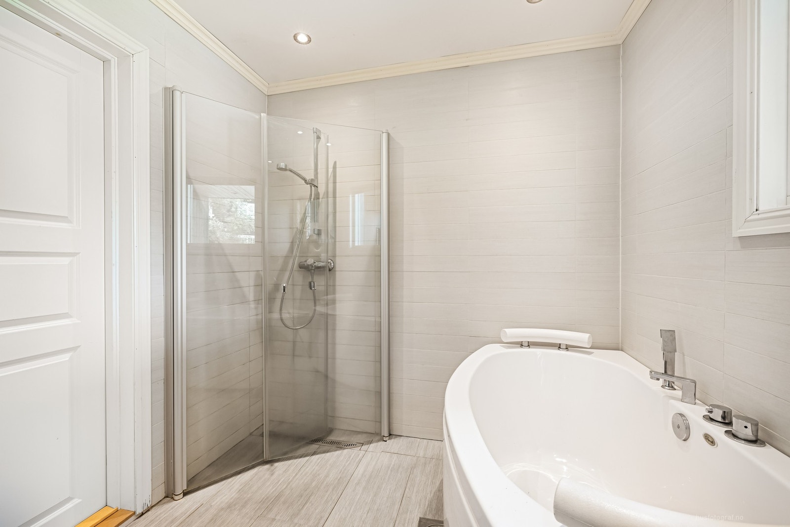 Badet er innredet med badekar, dobbel servant, baderomsinnredning, vegghengt toalett og dusjhjørne Galleribilde