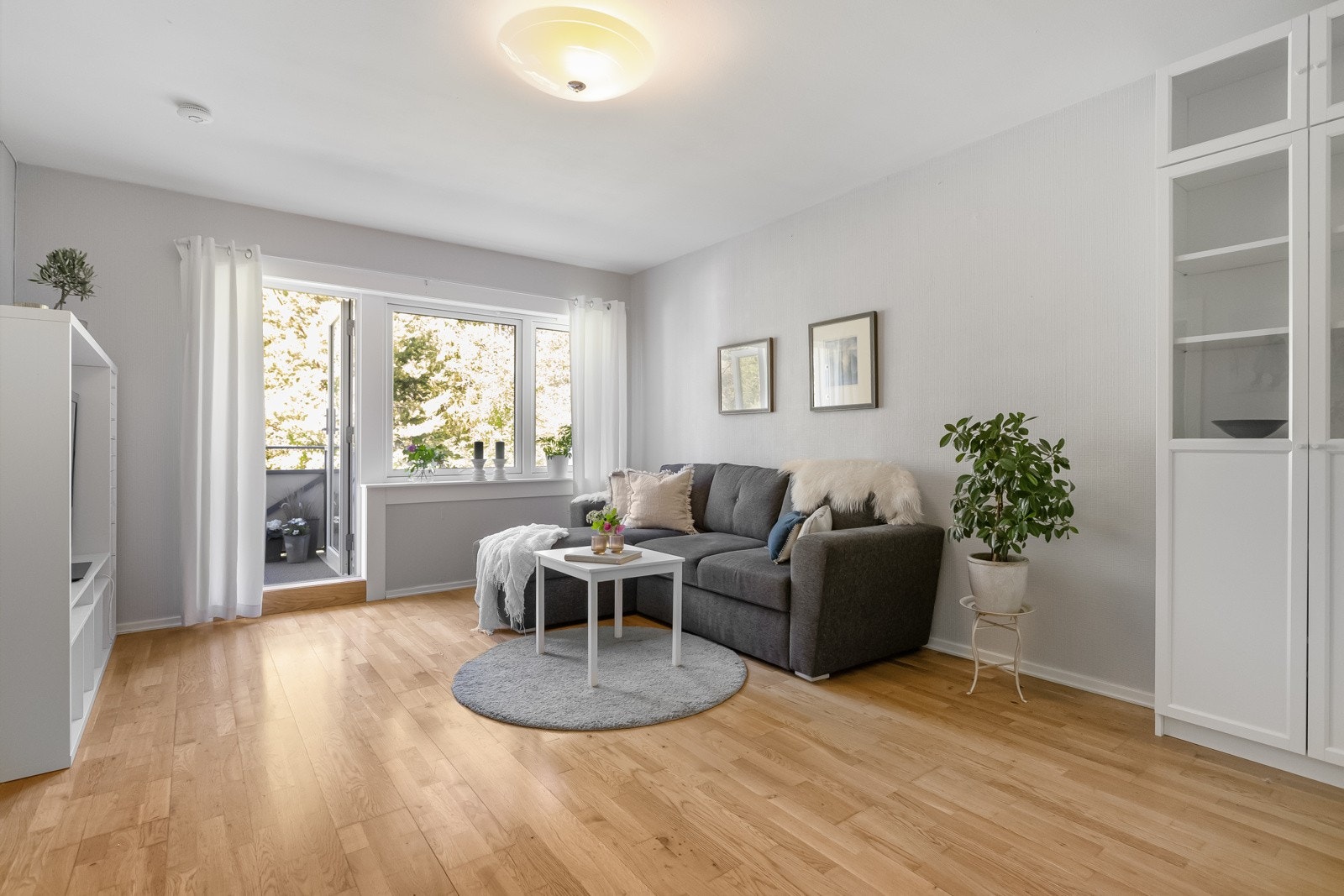 Stor og lys stue med parkett på gulv. Galleribilde