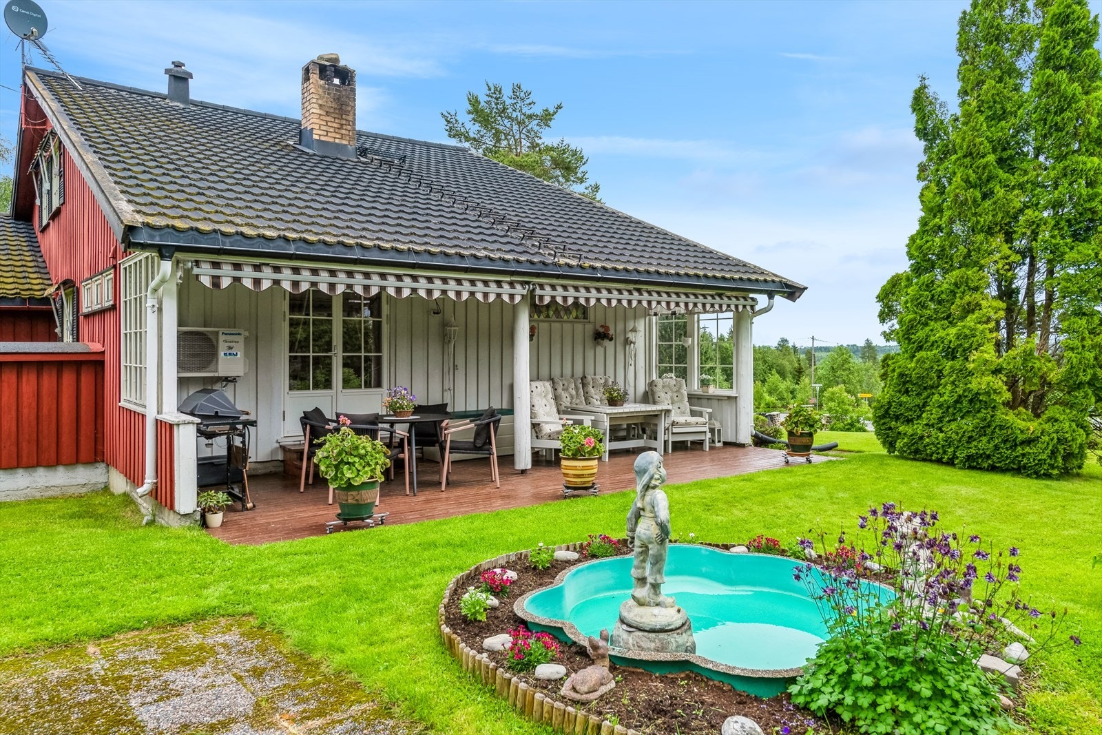 Idyllisk hage som er pent opparbeidet med plen og beplantning. Galleribilde