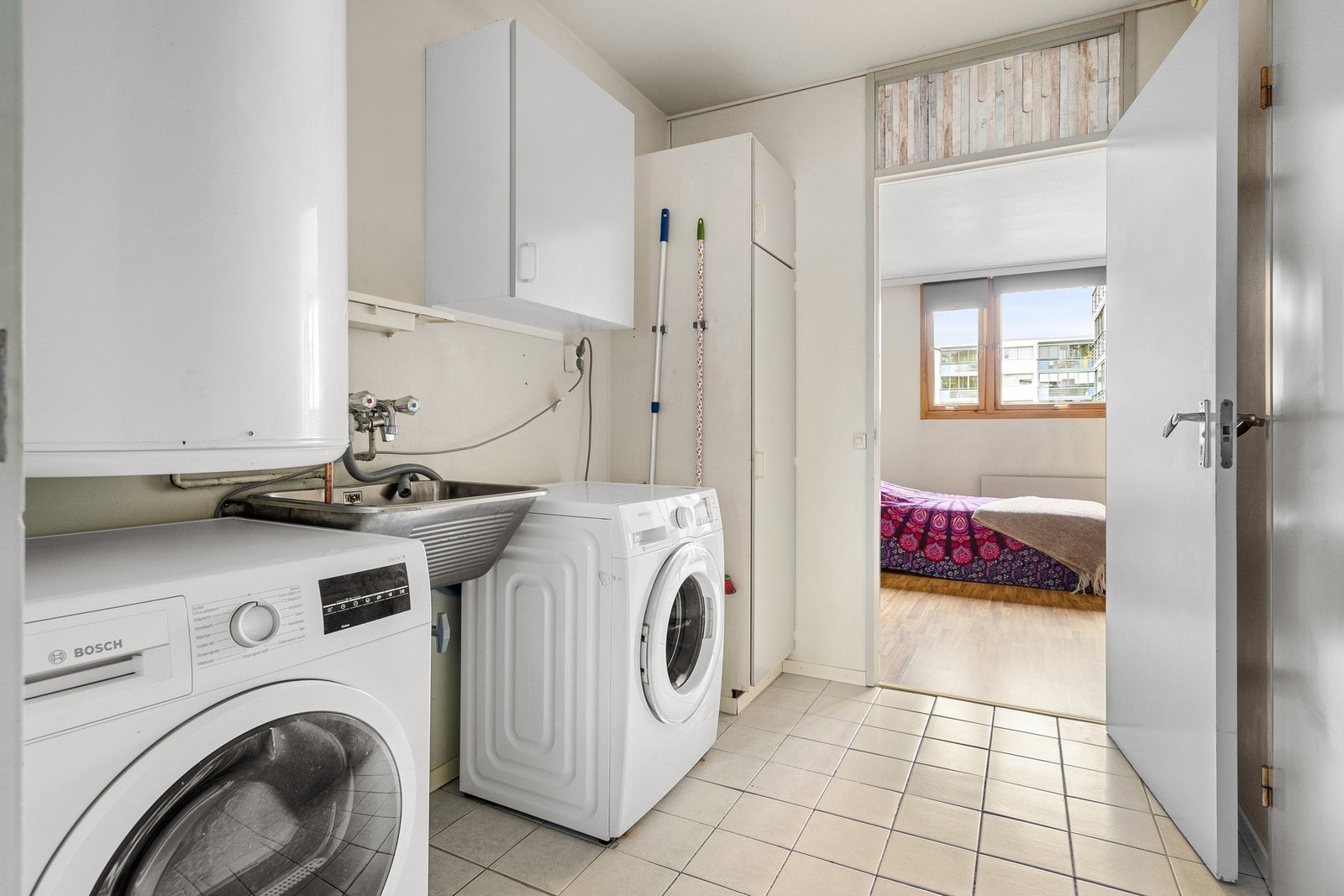 Praktisk eget vaskerom med flis på gulv. Galleribilde