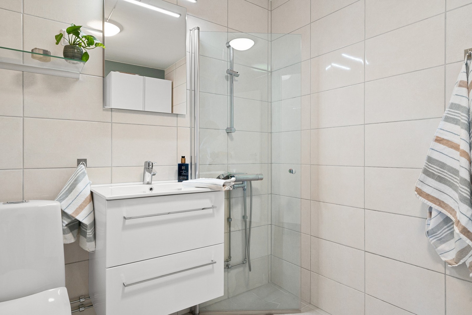 Badet er utstyrt med bl.a. klosett, dusjhjørne og servant. Galleribilde