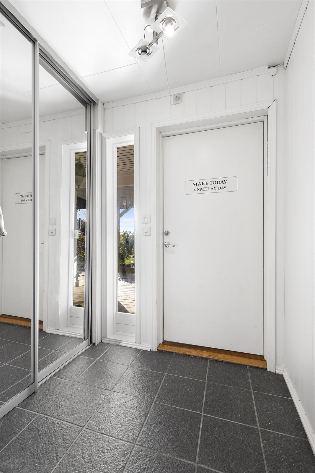 Underetasjen har egen inngang i tillegg til trapp innvendig. Entré en er innredet med skyvedørsgarderobe og fliser på gulv. Galleribilde