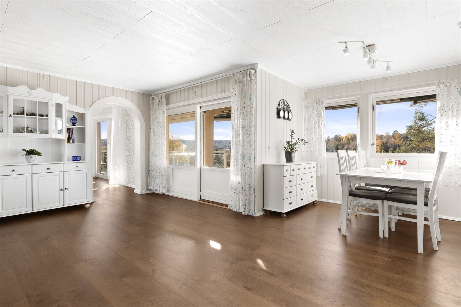 Oppholdsrommet er lyst og pent med panel på vegger og mange vindusflater. Utgang til stor terrasse på hele 60 m² Galleribilde