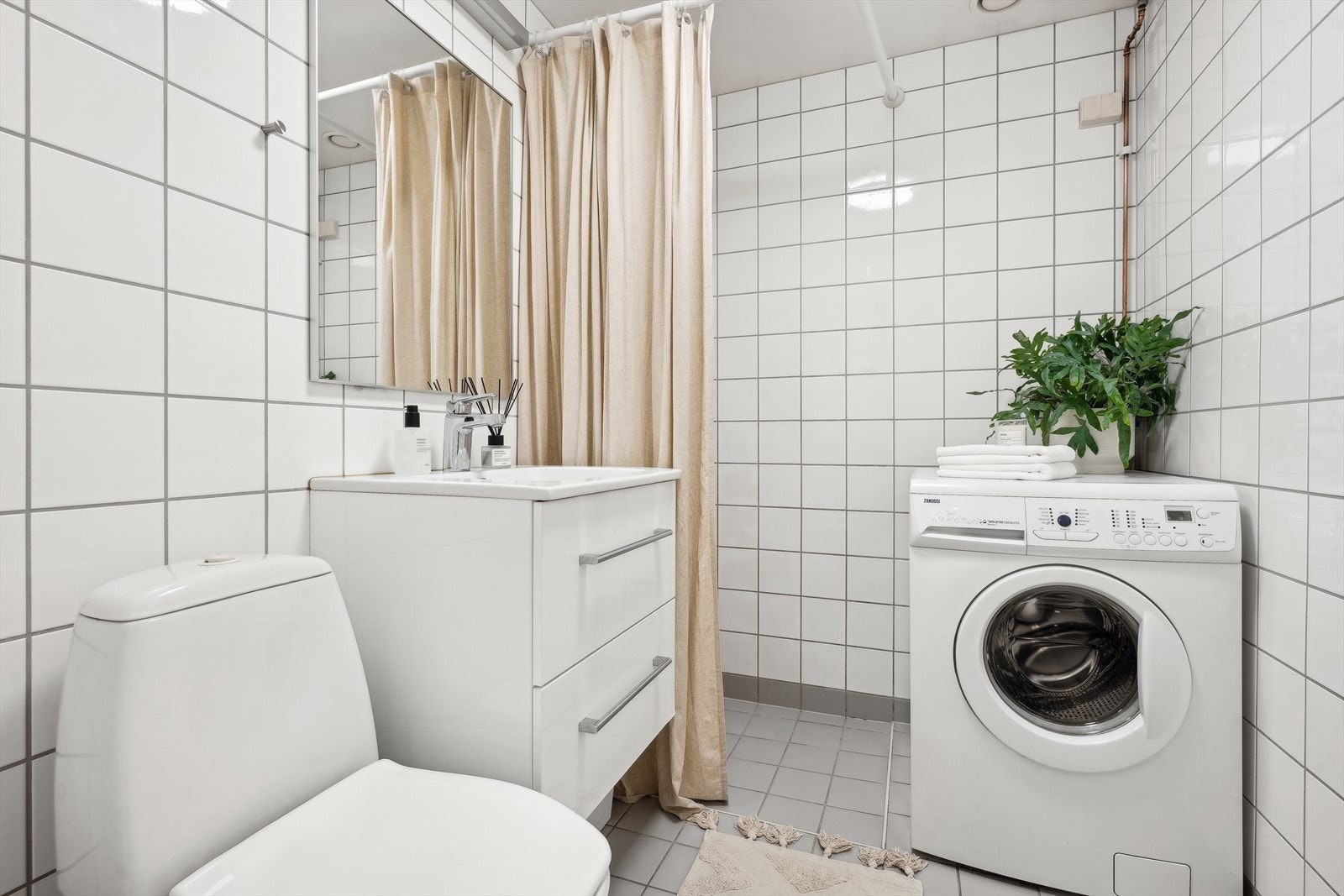 Det lyse badet er ifølge tidligere salgsoppgave fra 2004 og har hvite fliser på vegger og grå fliser på gulv med gulvvarme. Galleribilde